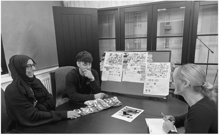 LPD team members having a meeting around a table with a moodboard