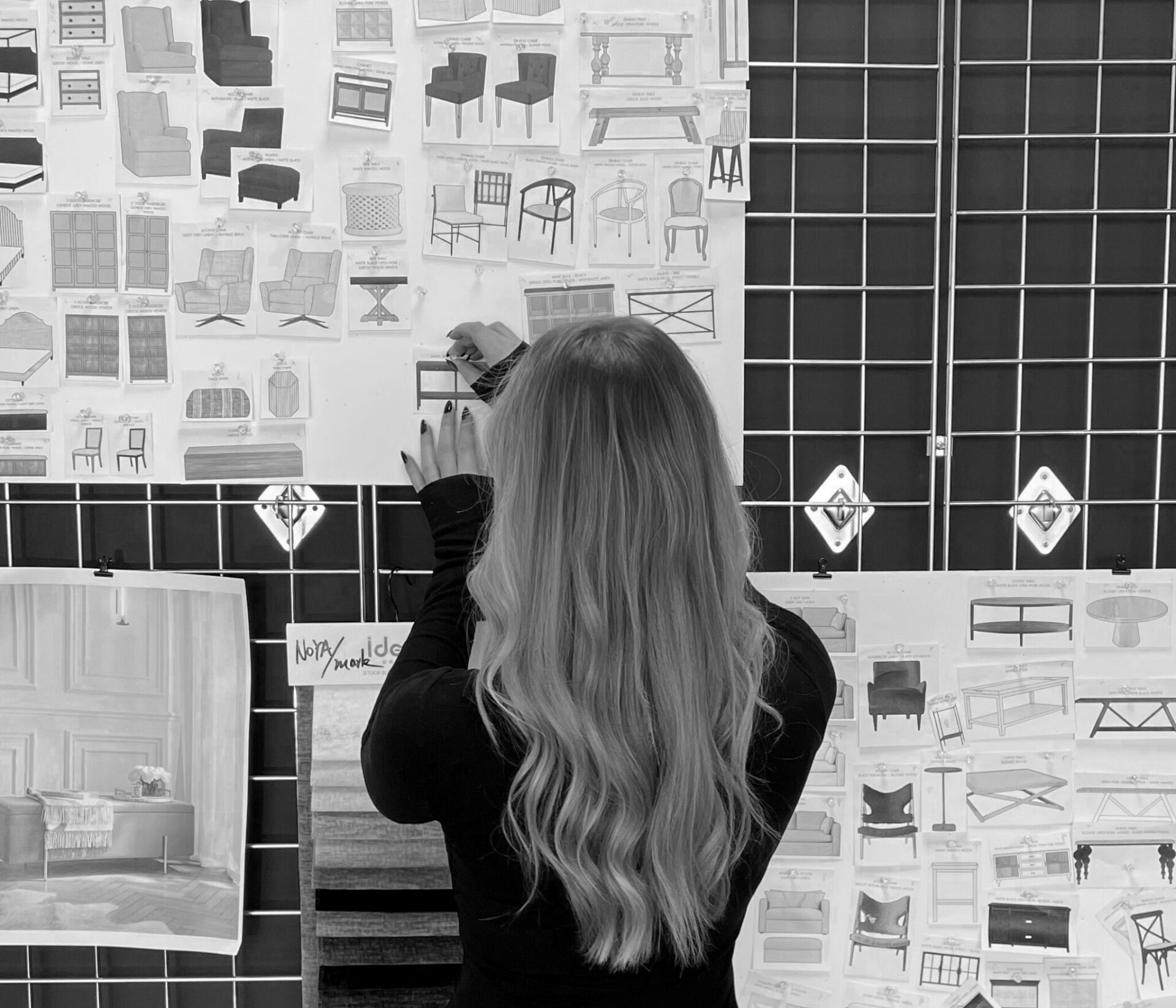 designer standing at a moodboard with back to the viewer 