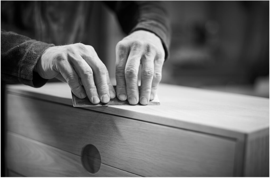 carpenter sanding a cabinet